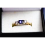 A 9 carat gold three stone tanzanite and synthetic ring,