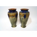 A pair of Royal Doulton stoneware vases with raised decoration of floral swags over a sage green