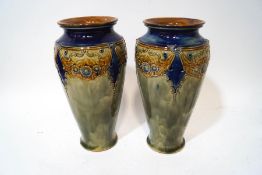 A pair of Royal Doulton stoneware vases with raised decoration of floral swags over a sage green