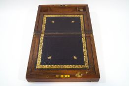 A Victorian walnut writing slope, with tooled gilt leather writing surface,