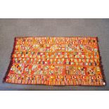 A Kazakhstan rug with brightly coloured threads in a multitude of flower patterns and shapes,
