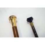 Two simple walking canes, one with blue glass knop,