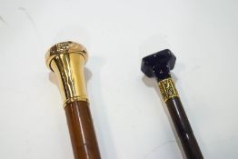 Two simple walking canes, one with blue glass knop,