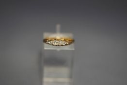 A five stone diamond ring, circa 1900, the small graduated old cut stones to a carved head mount,