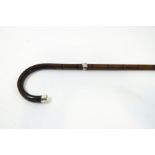 A slim bamboo walking stick with horn handle and silver tip and band, London hallmark,