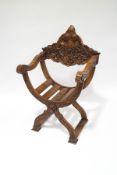 A 19th century Venetian walnut X-frame chair, with slatted seat below a heavily carved back,