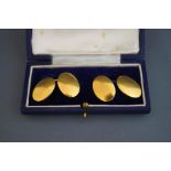 A pair of cufflinks, the plain oval panels stamped '18ct', 17.