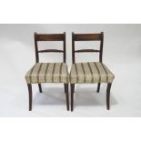 A pair of 19th century mahogany rope back dining chairs with upholstered seats and standing on
