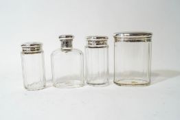 A set of four silver topped glass toilet bottles, by Adie Brothers,