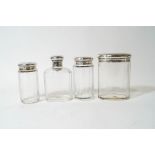 A set of four silver topped glass toilet bottles, by Adie Brothers,