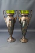 A pair of WMF electroplated two handled vases, with green glass liners, marks to underside,