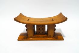 An African hardwood headrest with carved patterns,