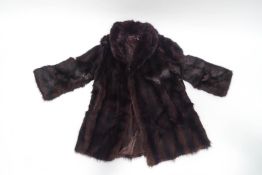 A musquash 3/4 length fur coat with wide collar, approximately size 10,