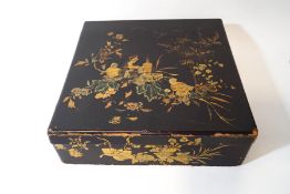 An early 20th century Japanese lacquered box, decorated with figures of a lady and her attendants,
