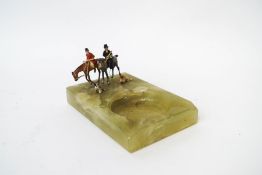 An onyx ashtray with cold painted bronze figures of two ladies foxhunting and their dogs,