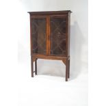 An Edwardian mahogany display cabinet with astragal glazed doors enclosing three shelves,