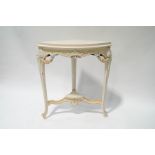 A French style painted corner table with carved Classical decoration and undertier,