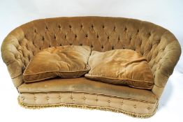 A 1930's button back sofa with curved back,
