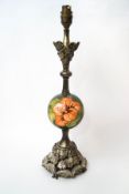 A metal table lamp with spherical Moorcroft central body,