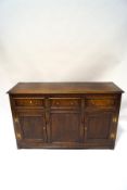 A 17th century style oak dresser base, three drawers with drop handles over two cupboards,