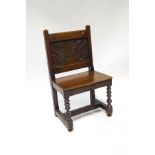 A 19th century oak side chair with heavily carved back, depicting a plant within a vase,