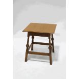 A square oak table, on turned legs, linked by rectangular stretchers,