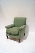 An early 20th century armchair with green fabric upholstery,