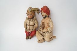 Two Indian dolls, one a cloth example of a turbaned man, kneeling while playing an instrument,