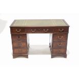 A mahogany pedestal desk with gilt tooled leather inset top with an arrangement of nine drawers on