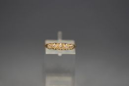 An 18 carat gold five stone diamond ring, the graduated old cuts to a carved head mount,