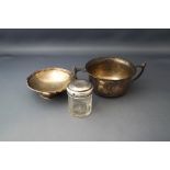 A silver two handled bowl; with a small silver footed dish; and a small silver topped toilet jar;