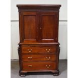 A reproduction George III style mahogany cupboard over 3 long drawers with carved cantered corners