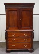A reproduction George III style mahogany cupboard over 3 long drawers with carved cantered corners