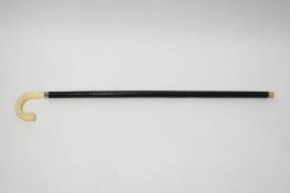 An ebonised walking stick with faux ivory handle