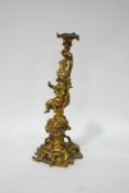 A 19th century French ormolu candlestick with a putti surrounded by C scrolls and flower garlands,