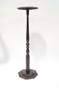 An early 20th century mahogany torchere, the octagonal top upon a turned column and stepped base,