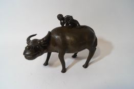 A Chinese bronze figure of a water buffalo and an immortal upon his back,