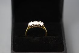 A three stone diamond 18 carat gold ring, the brilliant cuts totalling approximately 1 carat,