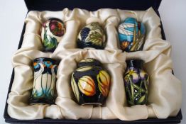 A set of six miniature Moorcroft vases,