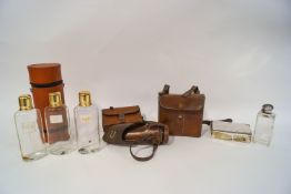 A plated spirit flask and sandwich tin, in leather case, a further glass and plated spirit flask,
