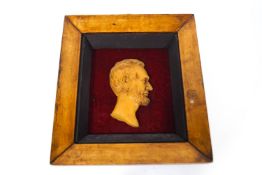 A 20th century wax profile bust of Abraham Lincoln in maple frame, 17.