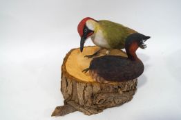 Ian Chappell (Contemporary), a carved wood Green Woodpecker on a tree trunk base, 23cm high,