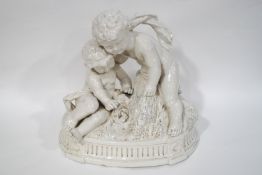 A 19th century Naples faience figure group of two Putti peering into a bird's nest,