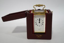 A miniature brass carriage clock, the dial signed Lionel Peck, with leather case and winding key,