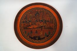 A Burmese lacquer tray decorated in red, green and black, with figures in an interior,