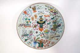 A 19th century Canton porcelain charger, decorated in polychrome enamels with an urn to the centre,