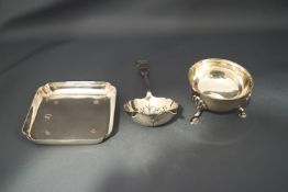 A silver tea strainer; a silver bowl; and a silver square dish;