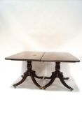 A Regency style mahogany double pedestal dining table, on outswept legs and brass paw casters,