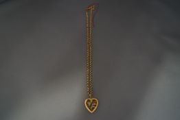 A necklace with a stone and split pearl set hollow heart shaped pendant, on a chain,