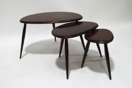 An Ercol pebble nest of three tables, on turned tapering legs, 40cm high x 65cm wide x 43cm deep,